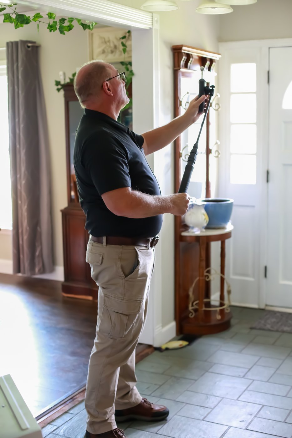 Joseph Caruso inspecting a property in a black ABCHI shirt